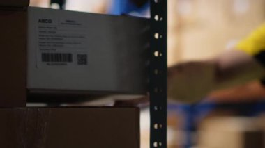 Paketlerdeki nakliye etiketlerini ve barkodları tarayan Asyalı bir çalışan, bir tarayıcı ile ruhsat etiketlemeyi ve envanter takibini yönetiyor. E-ticaret memnuniyet merkezi. Kamera B.