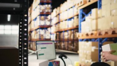 Yelek giyen Asyalı bir depo işçisi kutulardaki barkod etiketlerini tarıyor endüstriyel tatmin merkezinde perakende işlemleri yapıyor. Erkek personel teslimat için AWB kayıt etkinliğine katılıyor. Kamera A.