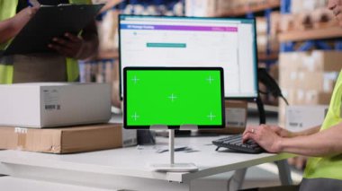 Asyalı çalışan, bilgisayar üzerinde izole edilmiş bir model ekran kullanıyor, tedarik zinciri sistemi ve paket izleme servisi için kullanılan bir iş yazılımı. Gerçek zamanlı sipariş tamamlama gösterimleri. Kamera B.