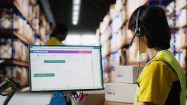 E-ticaret destek memuru kayıp paketler ya da dağıtım merkezindeki raflardaki kargo kutularıyla çevrili sipariş takibi gibi sorunlara cevap veriyor. Çağrı merkezi işlemleri kulaklıkla. Kamera B.