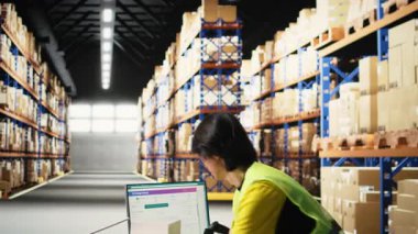 Karton kutulara nakliye etiketleri kaydetmek için tarayıcı kullanan Asyalı bir çalışan. Ekspres teslimat için profesyonel izleme yazılımı. Çevrimiçi büyük iş yerleri alışverişi. Kamera A.