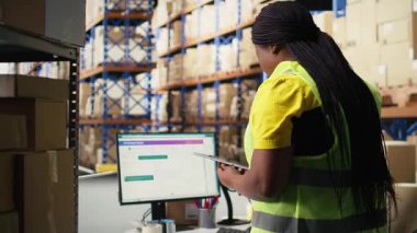 Depo çalışanı bilgisayar monitöründe paket izleme yazılımı kullanıyor, ekspres dağıtımı yönetiyor ve gerçek zamanlı paketleme durumunu güncellemek için awb izleme bilgisini kullanıyor. Dağıtım merkezi. Kamera A.