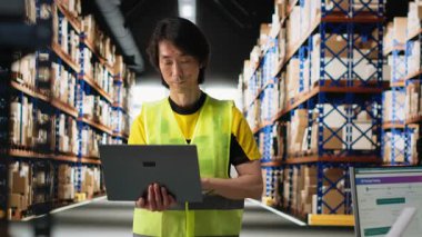 Asyalı erkek çalışanlar ürün işleme ve sipariş yerine getirilmesini denetliyor, verimli yerel dağıtım hizmetleri için teknoloji ve paket koordinasyonunu kullanarak envanter denetimini sağlıyor. Kamera B.