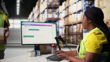 Barkodları yöneten personel, çevrimiçi alışveriş siparişleri, nakliye etiketli ürünler ve kolay teslimat için ayrıntıları tarama görevlerini aksatmaktadır. Memnuniyet merkezi çalışanı. Kamera A.