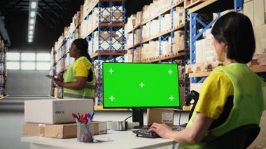 Lojistik işçisi yeşil ekran, depo otomasyon araçları ve envanter kontrol panellerinin yanında siparişleri yönetir. Depolama raflarıyla birlikte e-ticaret emri işlemleri. Kamera A.