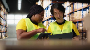 Çevrili alışveriş siparişlerini yöneten büyük işletme çalışanları kargo kutularıyla çevrili büyük raflar, ithalat ihracat dağıtım sistemi. Tatmin merkezi ürün kullanımını destekler. Kamera B.