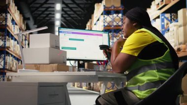 Endüstriyel depolama alanında uzun bir vardiya sonrasında aşırı çalışan Afrikalı Amerikalı kadın ayakta kalmaya çalışıyor. Yorgun personel üyesi. Kamera A.