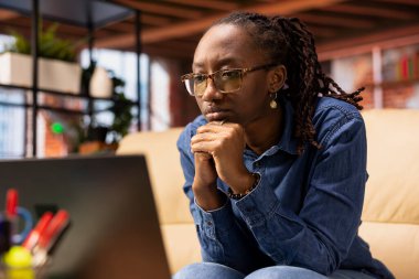 Evde dizüstü bilgisayarda internet gezen ve online bilgi araştıran, web sitelerine erişen ve o koltukta otururken makaleleri okuyan biri. Çalışma görevleriyle ilgili veri bul.