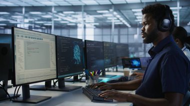 Bilgisayar bilimci sunucu odasında kulaklık takıyor, en az dinlenme süresini sağlamak için çalışıyor. Veri merkezinde podcast dinlemek için ses aygıtı kullanan mühendis, performansı gözlemliyor, kamera A