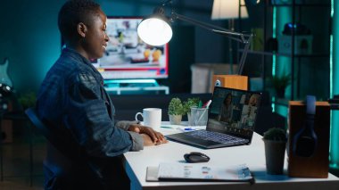 Ofisteki iş görüşmesi sırasında iş arkadaşlarıyla iş yerinde konuşan bir çalışan. Uzaktan telekonferansla konuşan tele-işçi oturma odasından, kamera A 'dan arıyor.