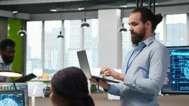 Yazılım sorunlarını düzeltmek ve sistem istikrarını geliştirmek için dizüstü bilgisayardaki yapay zeka algoritmalarını kodlayan neşeli programcı. Teknoloji şirketinin gülümseyen çalışanı, ayarları ayarlamak için dizüstü bilgisayar, kamera A 'yı kullanıyor.