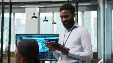 Happy programcı yazılım uygulamaları tasarlıyor ve geliştiriyor, performans ve ölçeklenebilirlik için kodu optimize ediyor. Dar geçitleri çözmek için tablet kullanan keyifli bilişim uzmanı, kamera A