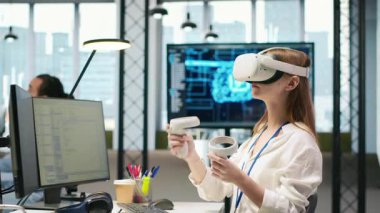 Küçük Dev sanal gerçekliği kullanarak üretken yapay zeka öğrenme algoritmalarını test ediyor. VR gözlük takan genç bir kadın AI büyük dil model kodu ve kamera A ile verimliliği ölçeklendiriyor.