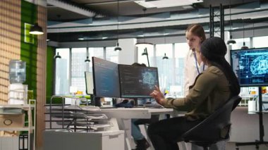 Gülümseyen başlangıç yöneticisi küçük Dev 'e makine öğrenme teknolojisini nasıl kullanacağını öğretiyor. Mutlu Afro-Amerikan takım lideri, stajyere yapay zeka öngörüsü modellerini nasıl kullanacağını gösteriyor. Kamera A.