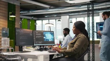 Performans ve hava tahminlerini optimize etmek için yapay zeka kullanan kadın yazılım geliştirici. Ofis eğitim makinesindeki kadın modelleri bilgisayar, kamera A kullanarak öğreniyor.