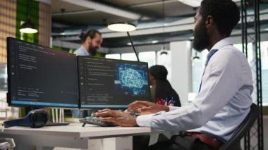 Ofis masasındaki sistem yöneticisi yapay zeka otomasyonunu kullanarak yazılım uygulamaları geliştiriyor. Bilgisayar üzerinde çalışan bir bilişim uzmanı. Yapay zekayla hata ayıklama uygulamaları. Kamera A.