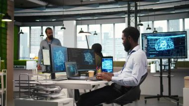 Ofisteki yönetici yapay zeka makinesinin birden fazla aygıt üzerinden görevleri çalıştırmayı öğrenmesine ve ekranlardaki ilerlemeyi izlemesine güveniyor. IT uzmanı yapay zeka modelleri geliştirmek için sinirsel ağlar kullanır, kamera A