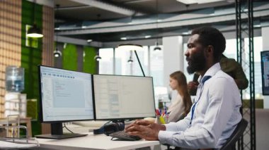 Kodlamak için bilgisayar kullanan teknisyen, hataları en aza indirmek için uygulamaları test ediyor, sistem istikrarını geliştiriyor. Uygulama yapılandırması, kamera A yoluyla performansı optimize eden teknoloji başlangıç ofisi uzmanı