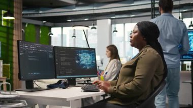 PC 'de kadın teknisyen kod yazıyor, sinirsel ağ API' leri geliştiriyor. Sistem yöneticisi, yazılım hatalarını yapay zeka teknolojisiyle gidermek için bilgisayar kullanıyor. Kamera A