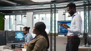 Ofisteki neşeli teknisyen yapay zeka senaryoları kullanarak tekrarlanan görevleri otomatikleştiriyor. Uzun metrajlı uygulamayı hızlandırmak için yapay zeka kullanan iş yerindeki neşeli adam, kamera A