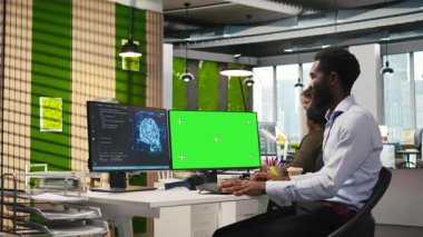 Makine öğrenme API 'leri geliştiren yeşil ekran bilgisayarında mühendis kodu yazıyor. BT uzmanı, yapay zeka ve kamera A kullanarak yazılım hatalarını gidermek için PC kullanıyor.