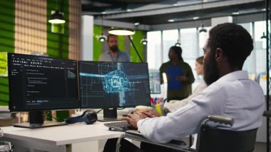 Tekerlekli sandalyedeki teknisyen yapay zekayı kullanarak performansı ve tahminleri optimize ediyor. Kapsayıcı ofis eğitim makinesi öğrenme engelli Afrikalı Amerikalı çalışanlar, kamera A