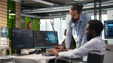 Parapleji beyin fırtınası yapan, makine öğrenme teknolojisiyle çalışan bir mühendis ve iş arkadaşı. Tekerlekli sandalyedeki adam ve ofisteki iş arkadaşı verileri yapay zeka öngörücü modellere dönüştürüyor, kamera A