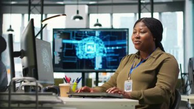 Kod yazmak için bilgisayar kullanan kadın teknisyen, makine öğrenme API 'leri geliştiriyor. Afro-Amerikalı kadın yazılım hataları ve hataları için yapay zeka, kamera A kullanıyor.