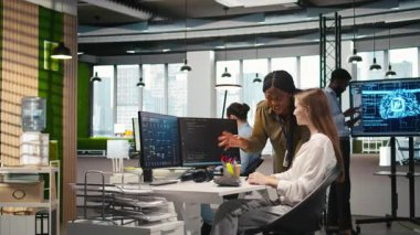 İş yerindeki küçük devlerin başarılarını tanıması ve olumlu ofis kültürünü teşvik etmesi memnuniyet verici. Neşeli Afrikalı Amerikalı yönetici kadın mühendis tarafından yazılan kodları överek, beşlik çakıyor, kamera A