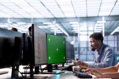 Veri merkezindeki programcı, sunucuları kullanılabilir yazılım zayıflıklarından korumak için yeşil ekran PC 'deki donanım sistemlerini günceller. Bilgi işlem uzmanı sunucuları etkileyen hataları bulmak için krom anahtar bilgisayarı kullanıyor