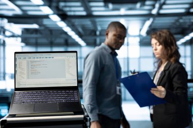 Veri merkezindeki dizüstü bilgisayardaki kod satırları ve bulanık arkaplan programcıları. IT uzmanları tarafından sunucu kümelerini denetleyen dizüstü bilgisayardaki programlama dilini kapat