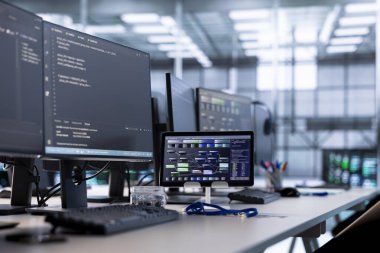 Boş yüksek teknoloji veri merkezindeki bilgisayarlar ve tabletler donanım enerji tüketimini izliyor. Sunucu odasındaki potansiyel sistem hatalarını kontrol etmek için kullanılan masadaki bilgisayar monitörleri