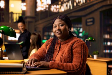 Ders materyallerini ve kaynaklarını kütüphanede hazırlayan kadın akıl hocasının portresi, uzmanlığını akademisyenlere danışmanlık yapmak ve genç zihinler için üretken bir akademik atmosfer yaratmak için kullanıyor..