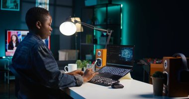 İç işlerinde yapay zeka uzmanı programlama dili kodları yazmak için dizüstü bilgisayar kullanıyor. Yapay Zeka Mühendisi uygulamayı oluşturmak için not defteri aygıtı kullanarak evden çalışıyor. Kamera B