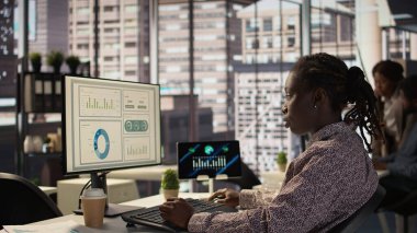 Stratejik planlama için finansal verileri analiz eden Afro-Amerikan personeli etkili iş operasyonları için kaynak tahsisini tartışıyor. Analizci finansal tahminler ve analizler yapar. Kamera B.