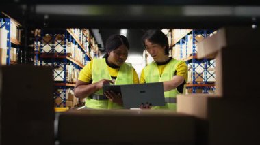 Çevrili alışveriş siparişlerini yöneten büyük işletme çalışanları kargo kutularıyla çevrili büyük raflar, ithalat ihracat dağıtım sistemi. Tatmin merkezi ürün kullanımını destekler. Kamera A.