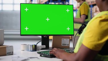 Afrikalı Amerikalı çalışanlar, bilgisayar üzerinde izole edilmiş bir model ekran, tedarik zinciri sistemi ve paket izleme servisi için kullanılan bir iş yazılımı kullanıyor. Gerçek zamanlı sipariş tamamlama gösterimleri. Kamera B.