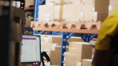 Depo çalışanı bilgisayar monitöründe paket izleme yazılımı kullanıyor, ekspres dağıtımı yönetiyor ve gerçek zamanlı paketleme durumunu güncellemek için awb izleme bilgisini kullanıyor. Dağıtım merkezi. Kamera B.