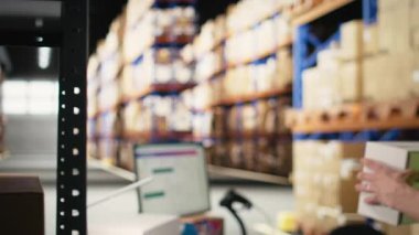 Paketlerdeki nakliye etiketlerini ve barkodları tarayan Asyalı bir çalışan, bir tarayıcı ile ruhsat etiketlemeyi ve envanter takibini yönetiyor. E-ticaret memnuniyet merkezi. Kamera A.