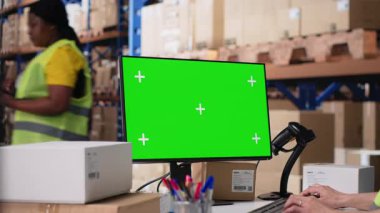 Lojistik işçisi yeşil ekran, depo otomasyon araçları ve envanter kontrol panellerinin yanında siparişleri yönetir. Depolama raflarıyla birlikte e-ticaret emri işlemleri. Kamera B.