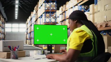 Yelekli bir depo işçisi, nakliye yazılımı teknolojisi, ambalaj sistemleri ve envanter yönetim araçlarıyla fotokopi alanı görüntüsü kullanır. E-ticaret lojistiğinde otomasyon. Kamera A.