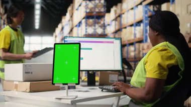 Hi vis Yelek 'teki depo çalışanı, nakliye yazılımı, ambalaj sistemleri ve envanter yönetim araçları teknolojisiyle fotokopi alanı görüntüsü kullanıyor. E-ticaret lojistiği. Kamera A.