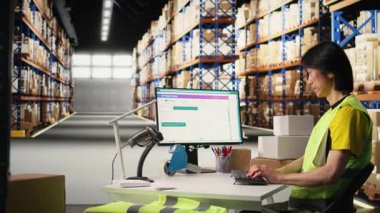 Depot Asyalı işçiler online alışveriş siparişlerini bilgisayarda işliyorlar, sevkiyat detaylarını yönetiyorlar ve profesyonel yazılımın gizli numaralarını öğreniyorlar. Paketleme ve envanter işlerini hallediyor. Kamera A.