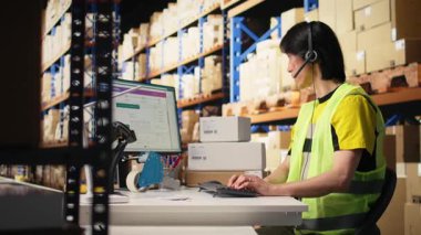 E-ticaret destek memuru kayıp paketler ya da dağıtım merkezindeki raflardaki kargo kutularıyla çevrili sipariş takibi gibi sorunlara cevap veriyor. Çağrı merkezi işlemleri kulaklıkla. Kamera A.