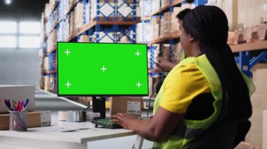 Lojistik çalışanı bilgisayarda izole edilmiş modellerin yanında paketler düzenliyor, sipariş izleme araçları yerleştiriyor ve etiketleme sistemleri yerleştiriyor. Personel üyesi, iş envanterini analiz ediyor. Kamera B.