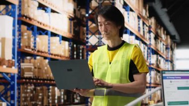 Çok ırklı personelin e-ticaret emirlerini işlemesi ve faturaları incelemesi endüstriyel depo alanlarında depolama raflarıyla kargo malları düzenlemesi. Düzgün dağıtım ve kalite kontrol. Kamera B.