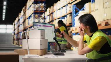 Uykucu Asyalı personel endüstriyel depoda patinaj ile uğraşıyor. Uyanık kalmak ve yazılımda kusursuz paket izleme hizmeti sağlamak için çabalıyor. Çok çalışan yorgun. Kamera A.