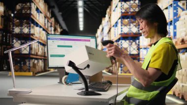 Endüstriyel personel, büyük tatmin merkezinde kutulardaki etiketleri tarıyor, barkod tarayıcısıyla nakliye lojistiği için nakliye etiketleri kaydediyor. E-ticaret için sipariş takibi. Kamera A.