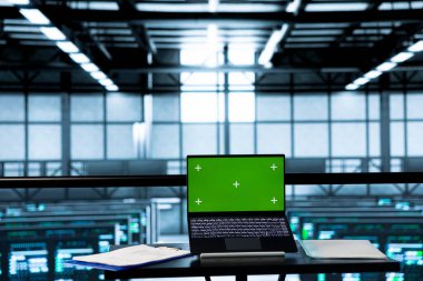 Güvenlik yamalarını çalıştırmak için kullanılan boş veri merkezindeki yeşil ekran model laptop. Sunucu odasında altyapıyı denetlemek için kimsenin kullanılmadığı izole ekran kroma anahtar dizüstü bilgisayar aygıtı