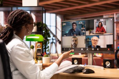 Yönetici, çalışanlarla video görüşmeleri sırasında konuşur. Evrakları inceler, iş vardiyalarını düzenler. Denetmen, personelle uzaktan telekonferans toplantısı yapıyor, belgeleri kontrol ediyor.